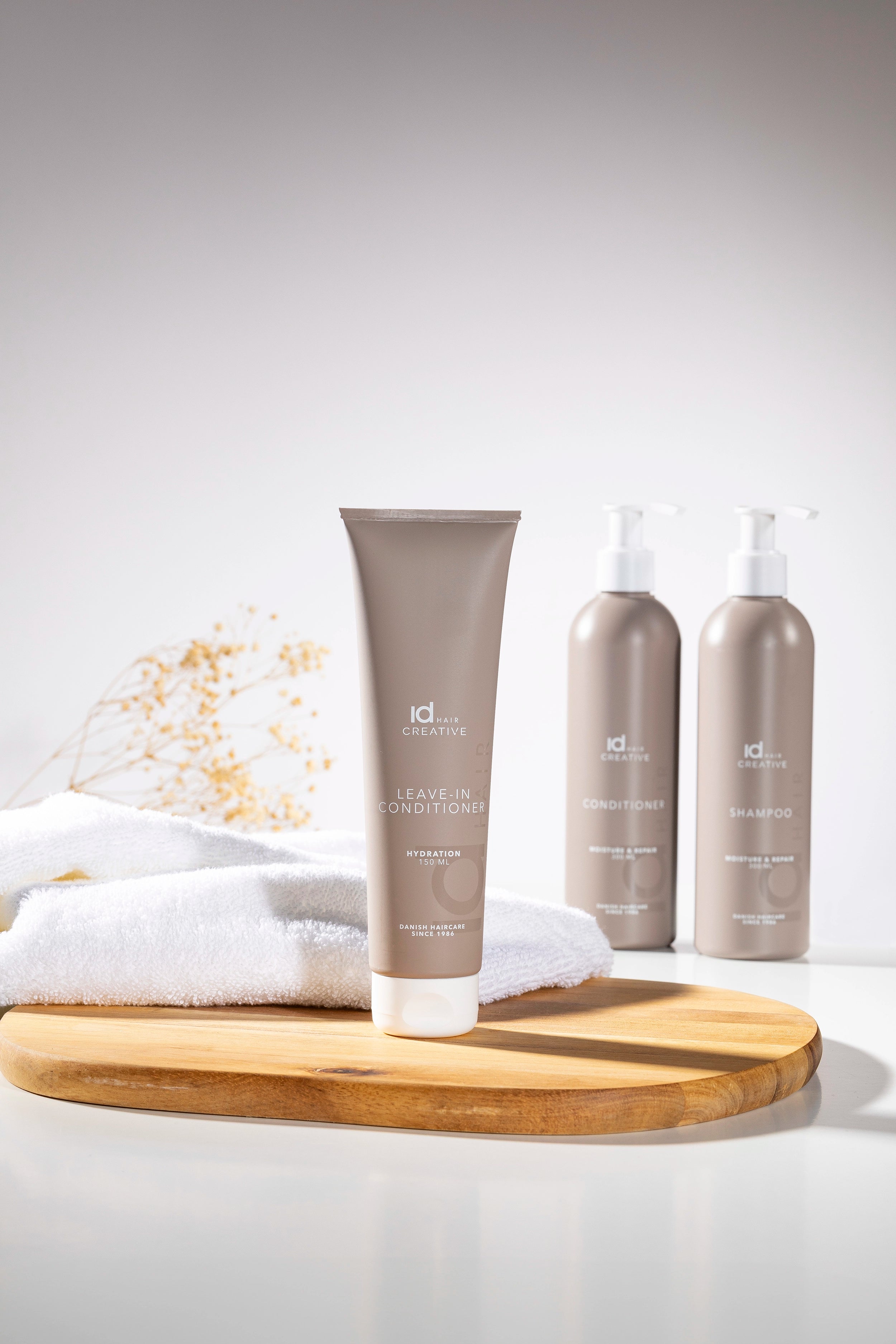 Hårplejeprodukter fra IdHAIR Creative opstillet i lyst miljø.