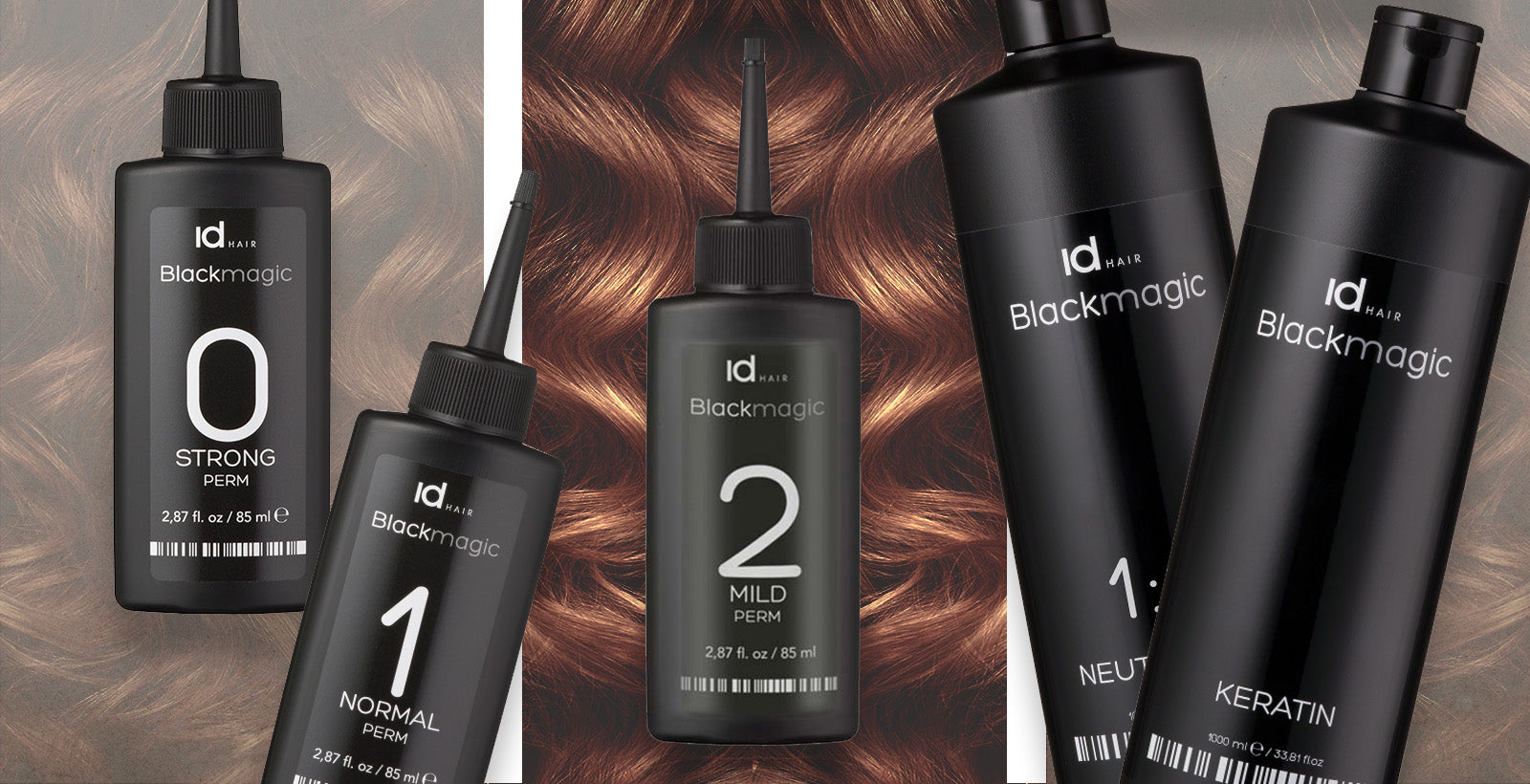IdHAIR Blackmagic permanentprodukter i sorte flasker foran kobberfarvet hårtekstur.