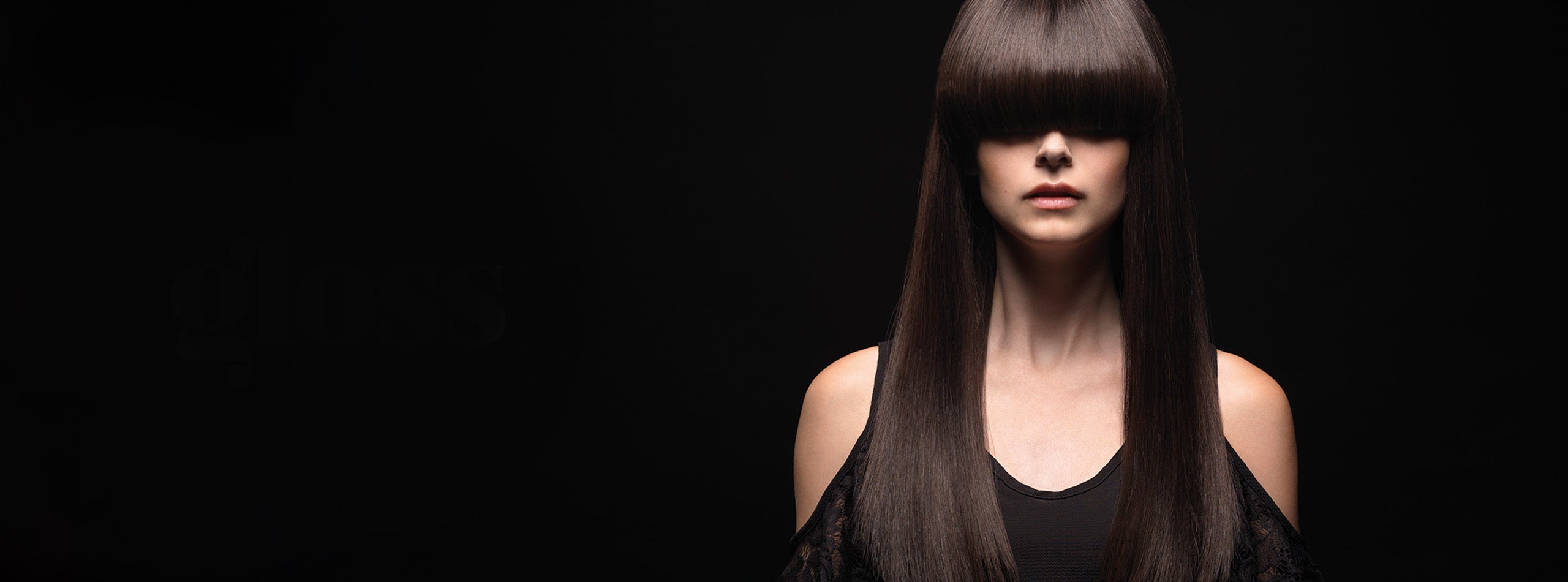 Kvinde med langt, glansfuldt mørkebrunt hår og lige pandehår mod sort baggrund.